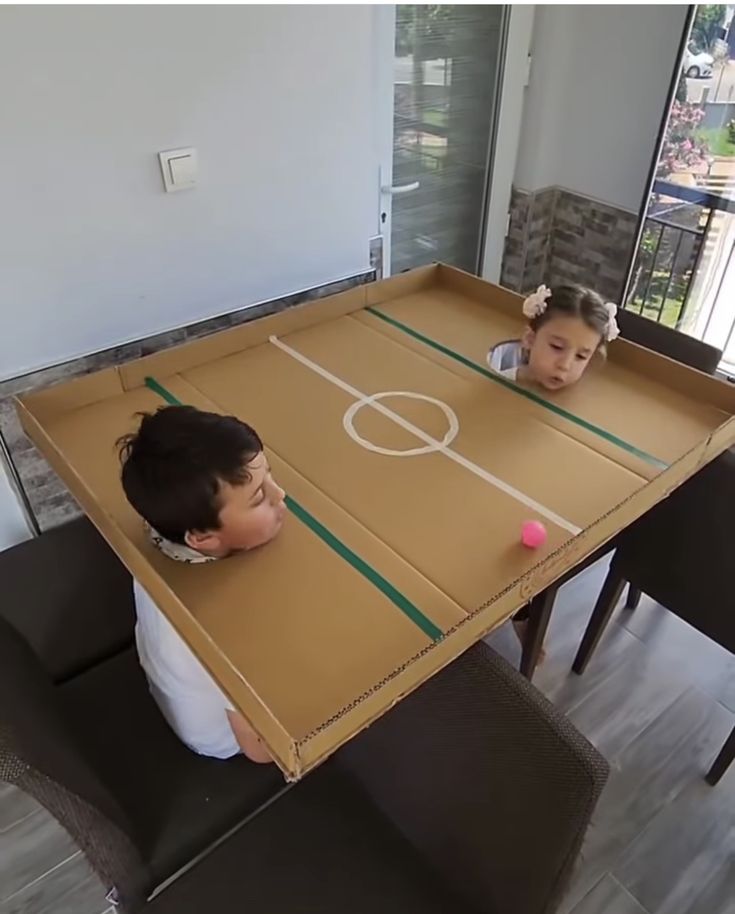 two children sitting at a table with a basketball game on it