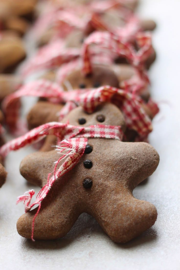 several gingerbread cookies with red and white ribbons tied around them are lined up next to each other