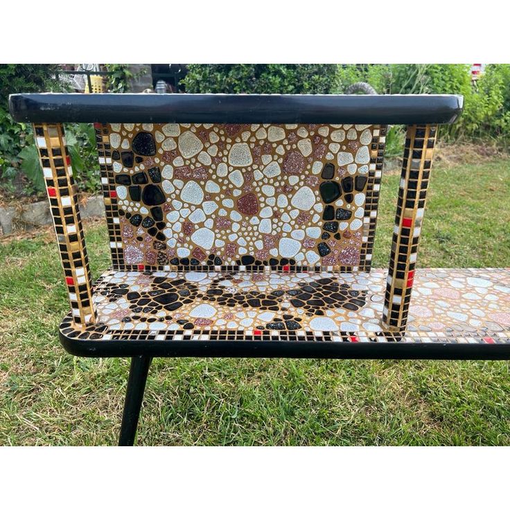 a bench made out of mosaic tiles in the grass