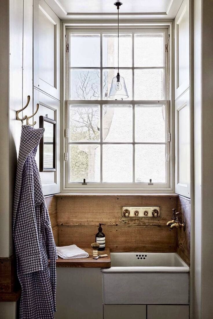 a kitchen sink sitting under a window next to a counter