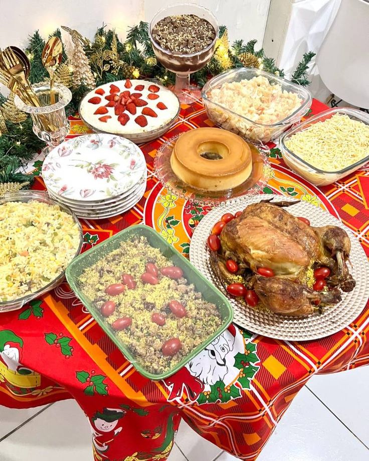 a table topped with lots of food on top of a red and yellow table cloth