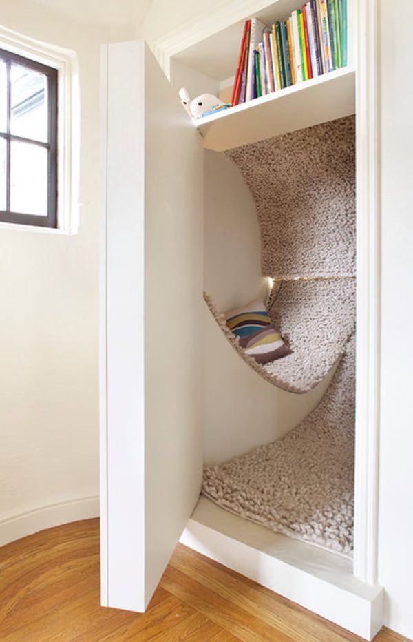 a book shelf with books on it in the corner of a room next to a window