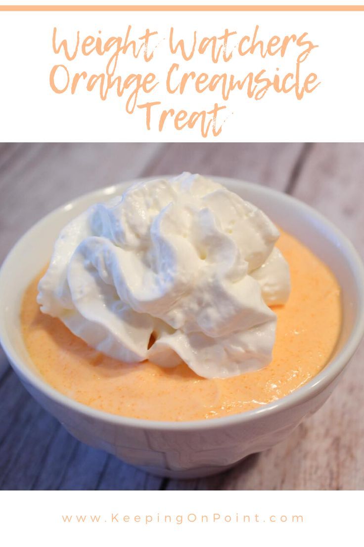 a white bowl filled with orange cream and whipped cream