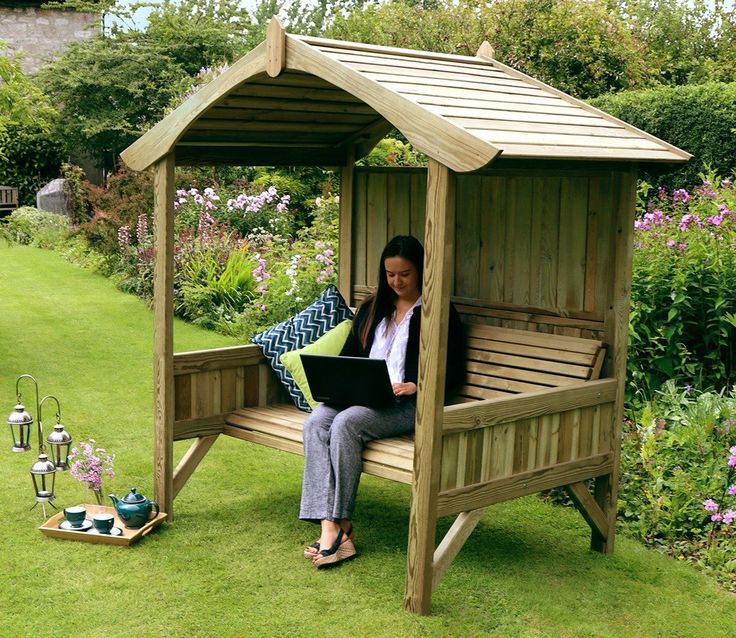 a woman sitting on a wooden bench with a laptop