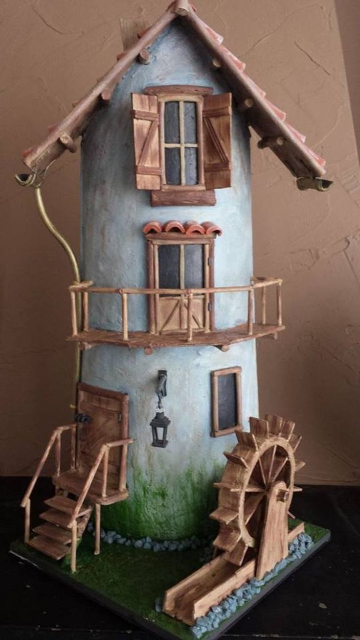 a doll house made to look like a water wheel and wooden ladders on the outside