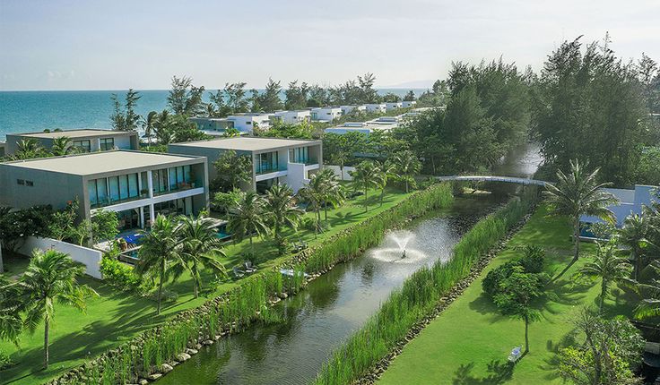 an aerial view of the resort and surrounding water features lush green grass, palm trees, and houses