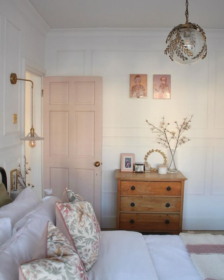 a bedroom with a bed, dresser and mirror on the wall next to a door