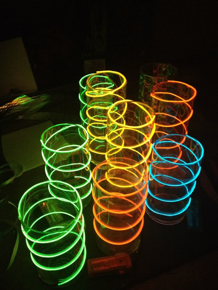 glowing neon rings on a table in the dark, with one lit up and several empty