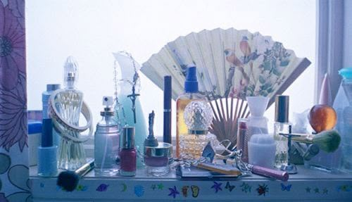 an assortment of cosmetics and perfume bottles sitting on a window sill