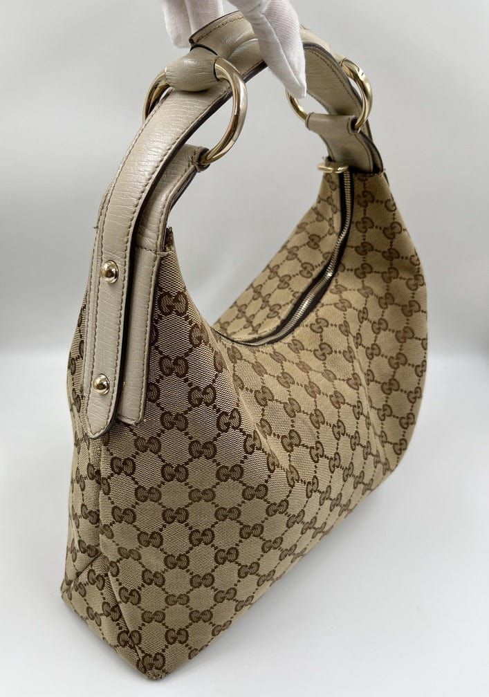 A stunning vintage Gucci hobo bag made from the iconic beige GG canvas with cream leather trim and pale gold hardware. Inside the bag is lined with a brown cotton lining and there is a zipped pocket for valuables. This bag is in excellent vintage condition, a true collectors item and comes with its original Gucci dust bag. There is some slight wear seen on the base corners. Gucci Hobo Bag, Gucci Horsebit, Pale Gold, Vuitton Bag, Diaper Backpack, Exclusive Bag, Flap Bag, New Bag, Hobo Bag