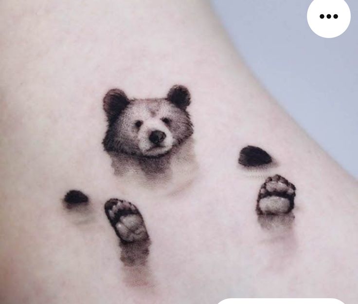 a bear's paw and foot prints on the back of a woman's thigh