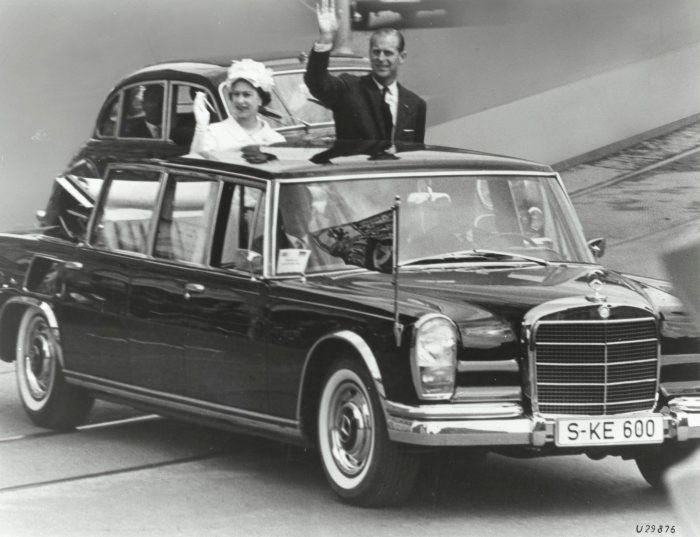 a black and white photo of people on top of a car