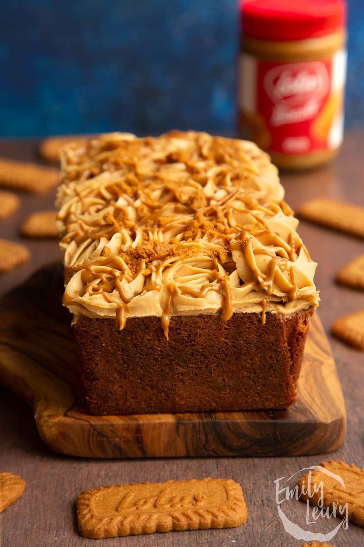 a loaf of cake sitting on top of a wooden cutting board next to crackers