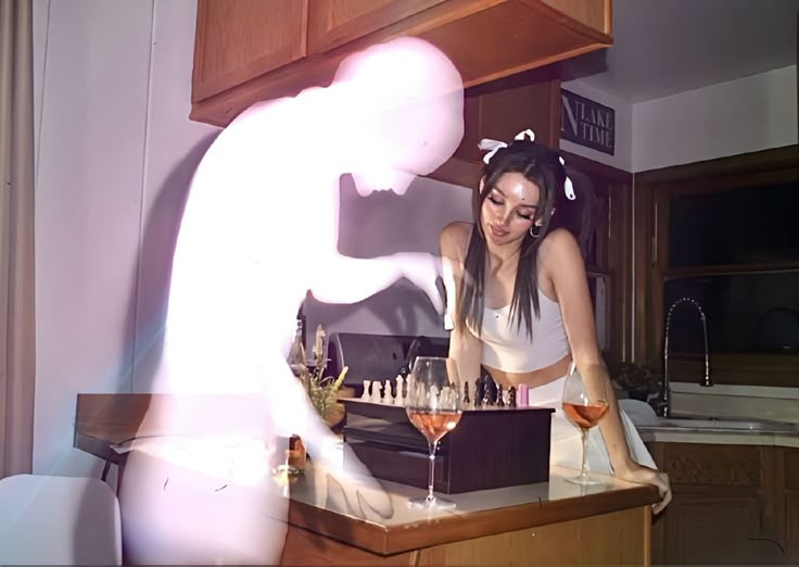 a woman standing in front of a counter filled with wine glasses