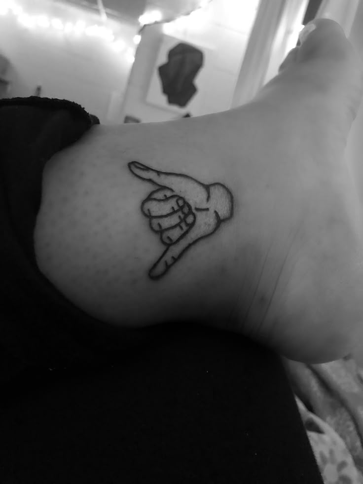 a black and white photo of a person's foot with a tattoo on it