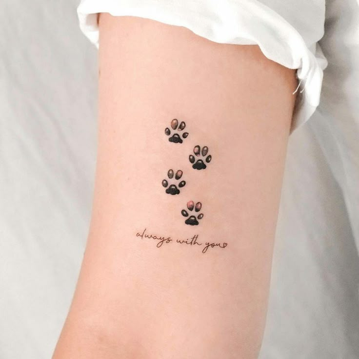 a woman with a tattoo on her arm that says, always walk by your paws