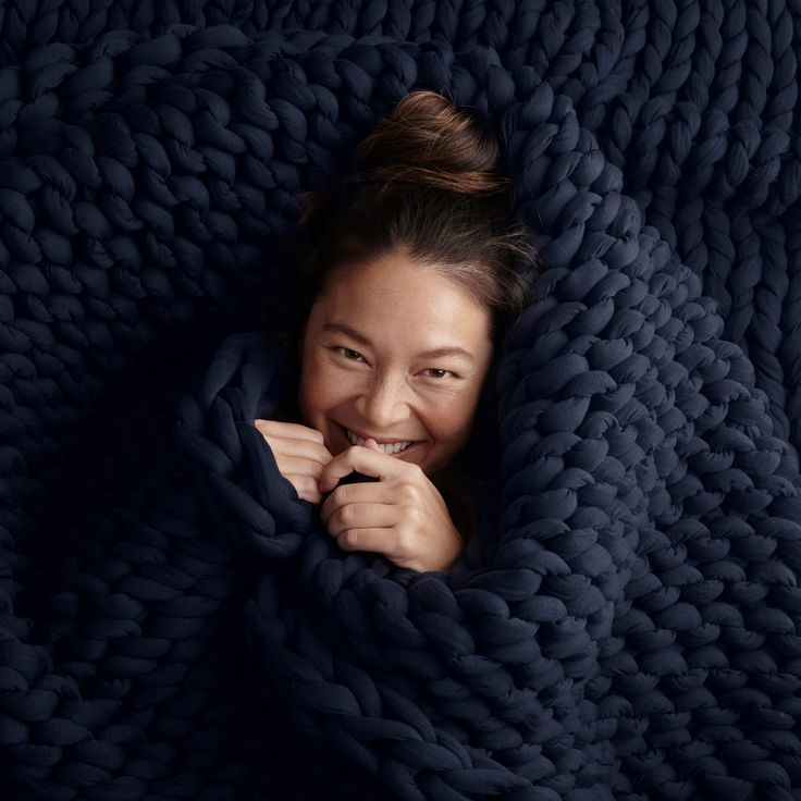 a woman wrapped in a blanket smiling at the camera