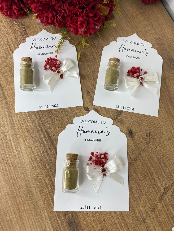 three small jars with flowers in them sitting on top of a table next to each other