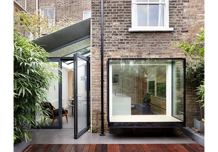 a house with an open glass door on the outside and wooden flooring in front of it