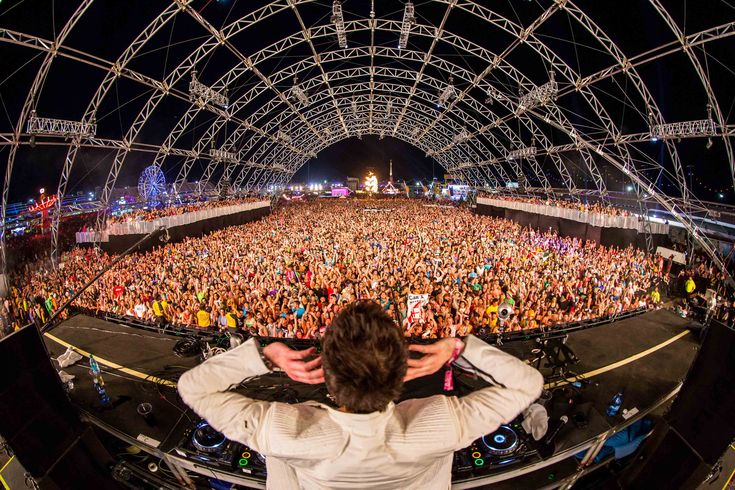 a man standing in front of a large crowd at a concert