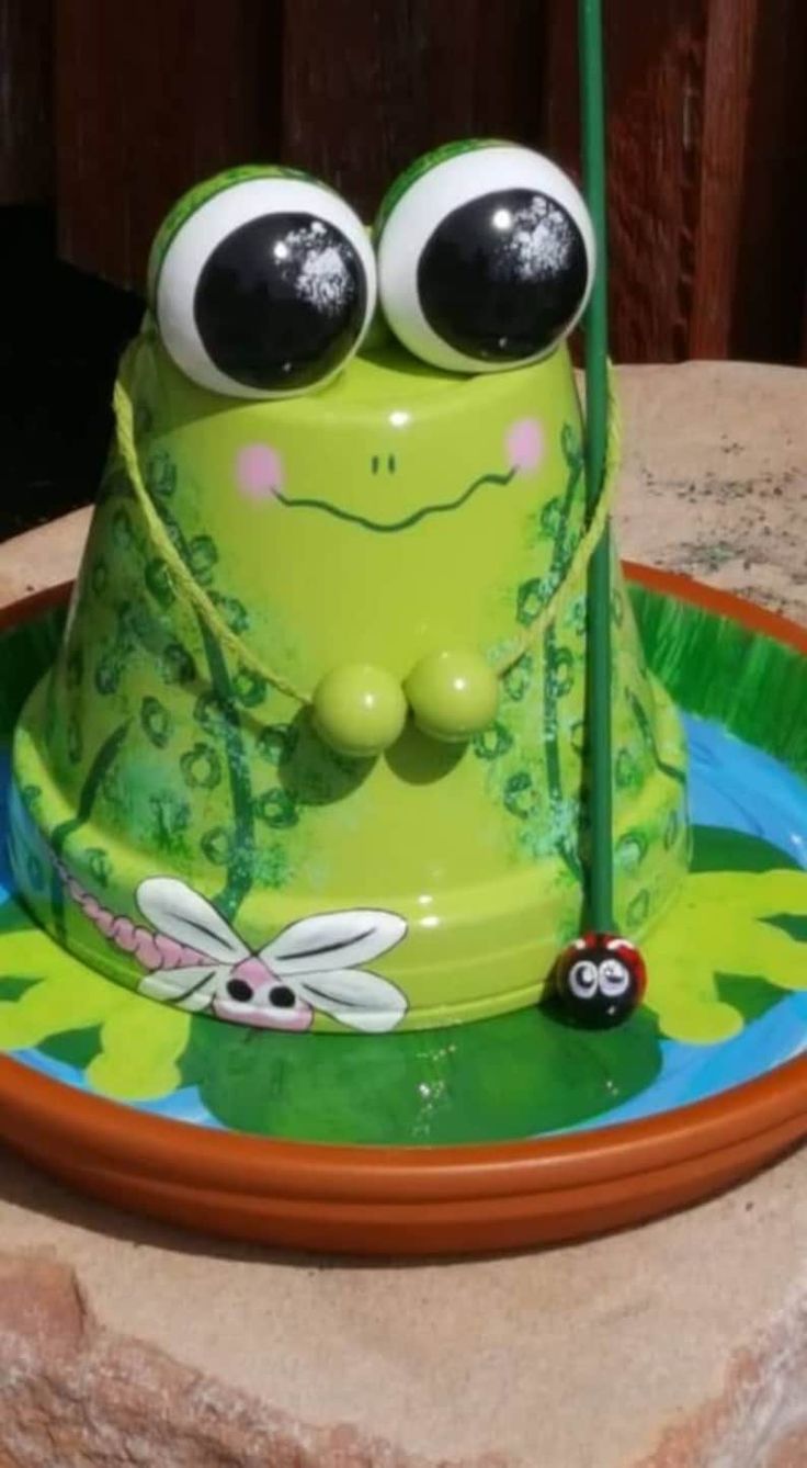 a green frog cake with large eyes on it's face, sitting on top of a plate