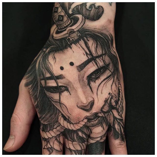 a person's hand with a tattoo on it and a woman's face