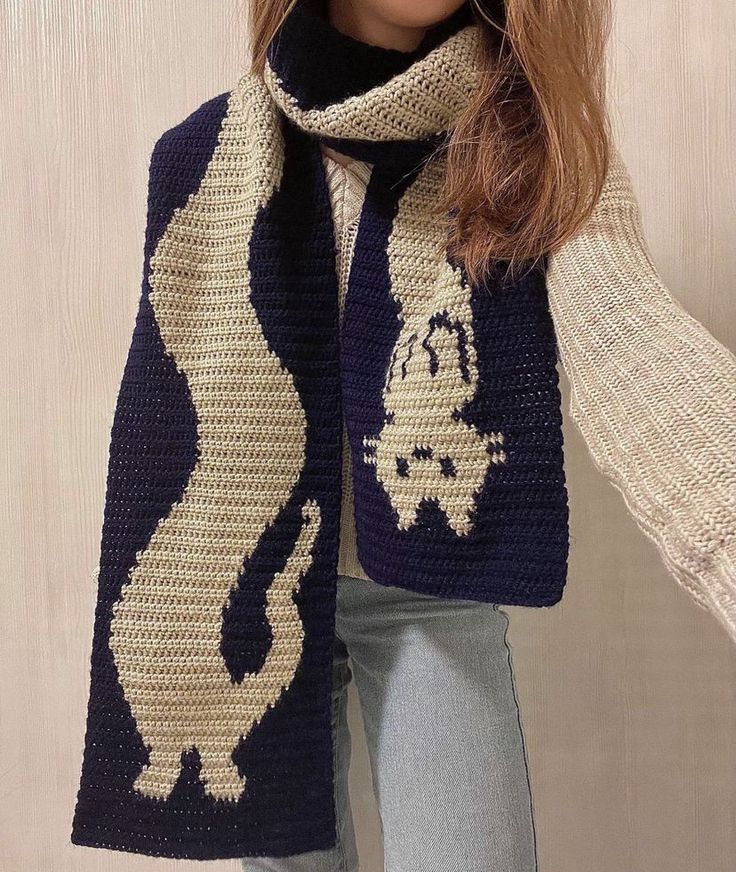 a woman wearing a knitted scarf with an animal motif