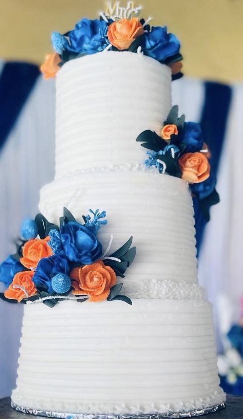 a wedding cake with blue and orange flowers on it