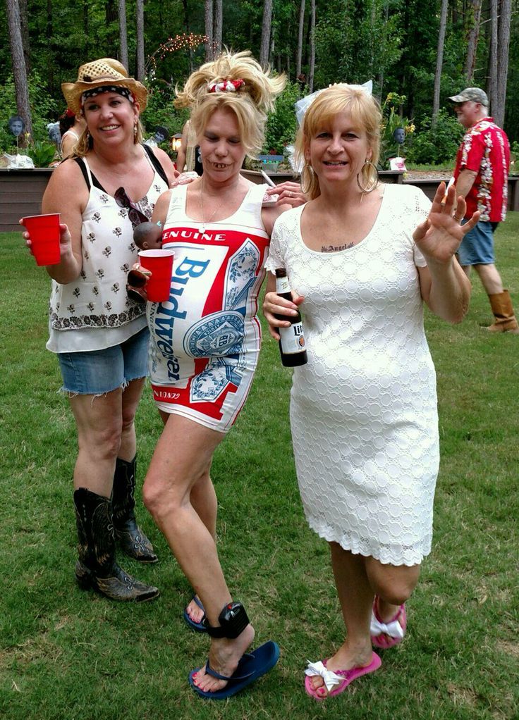 three women dressed in costumes posing for the camera with one holding a beer and two wearing flip flops