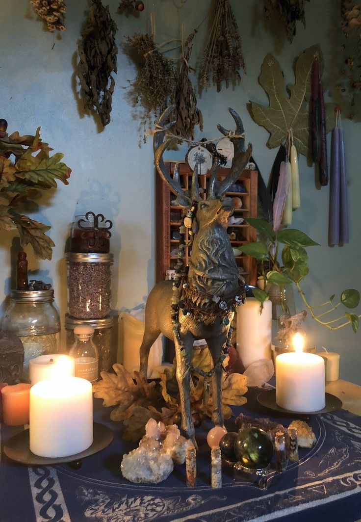 a table topped with candles and figurines on top of a blue cloth covered table