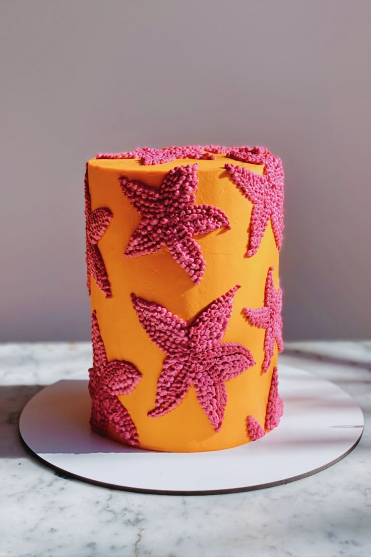 an orange and pink cake sitting on top of a white plate