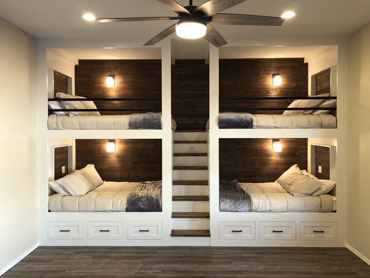 bunk beds are built into the wall in this room with white drawers and wood flooring