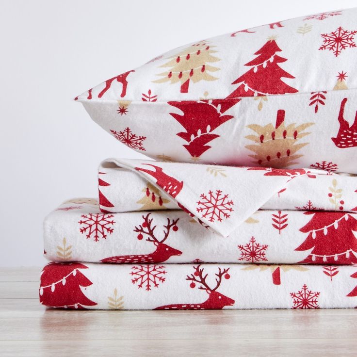 a stack of red and white sheets with christmas trees on them