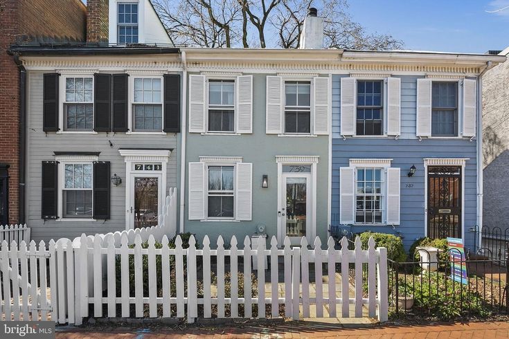 two story house with white picket fence in front