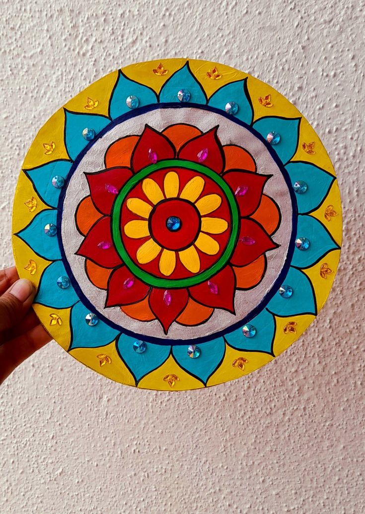 a hand holding up a colorful paper plate