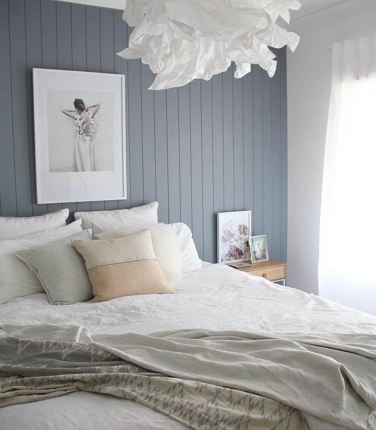 a white bed sitting in a bedroom next to a window