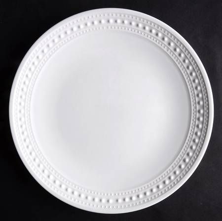 an empty white plate on a black background