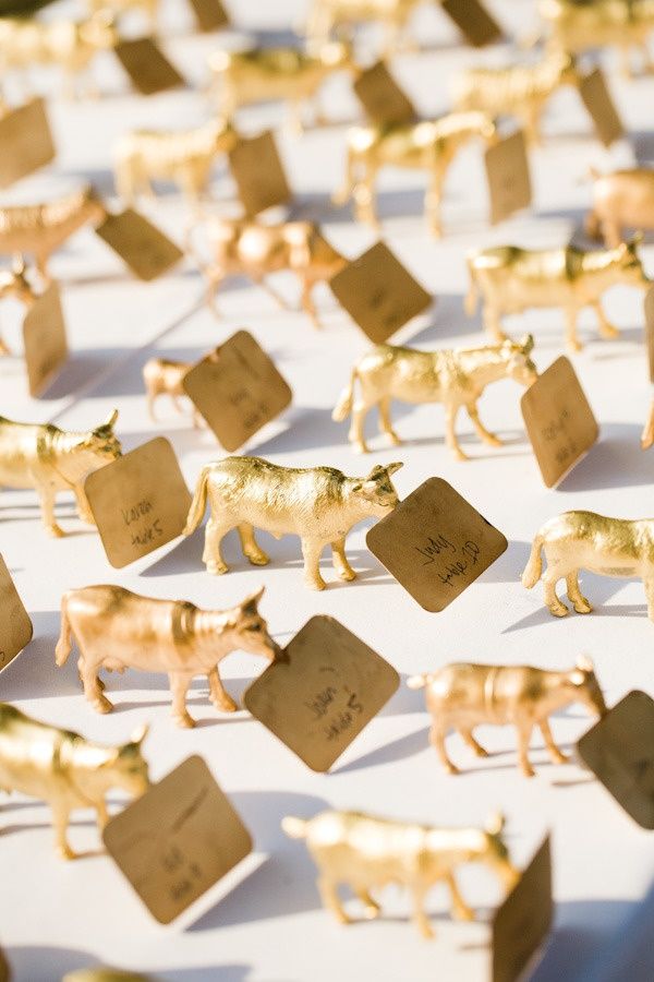 many small toy animals are lined up on a sheet of paper with tiny tags attached to them