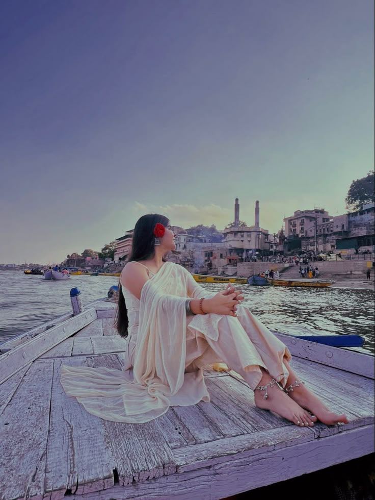 a woman sitting on top of a wooden dock