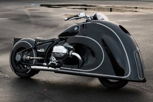 a black and silver motorcycle parked on the side of a road next to an empty parking lot