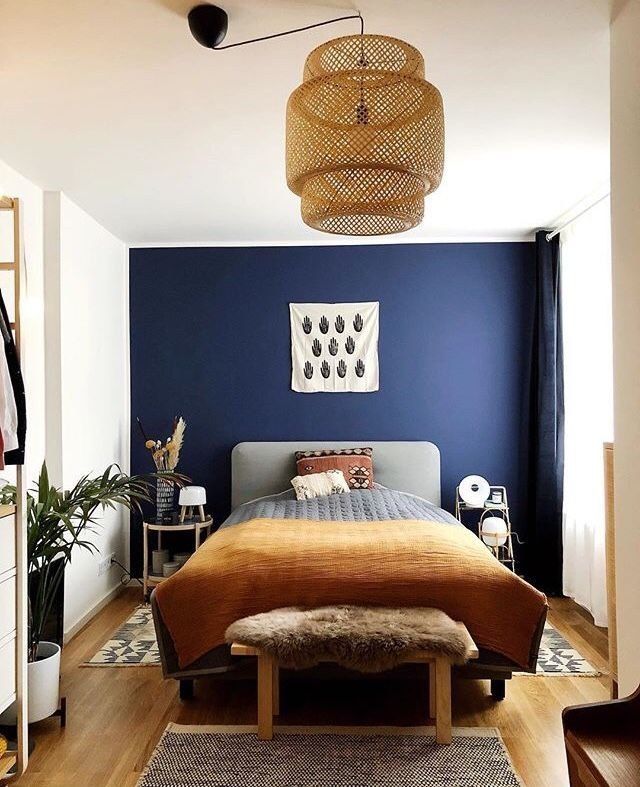 a bedroom with blue walls and wooden floors