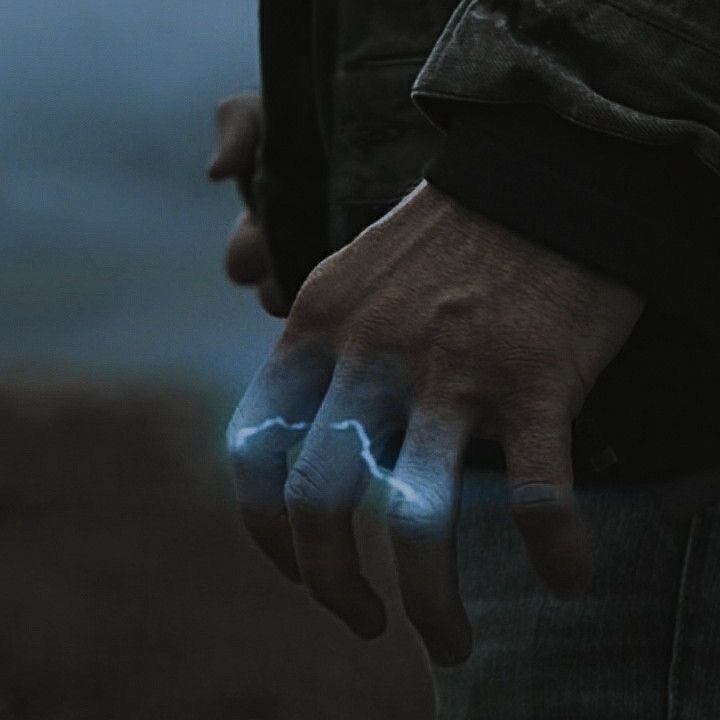 a man with his hand on the wrist has lightning drawn on it and is wearing a black jacket