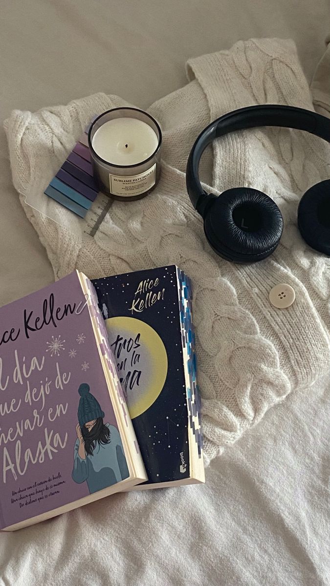 there is a book and headphones on the bed