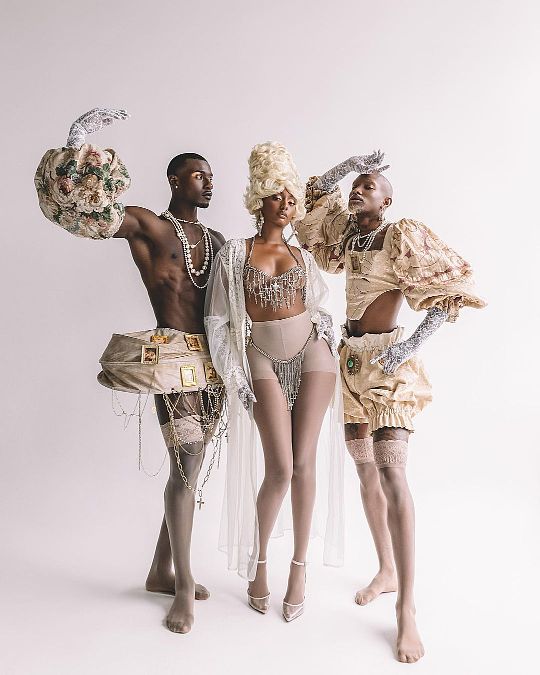 three people dressed in costumes posing for a photo