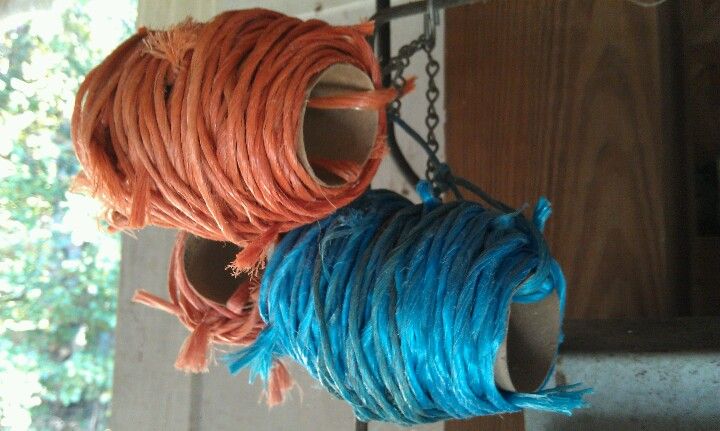 two spools of orange and blue yarn hanging from hooks