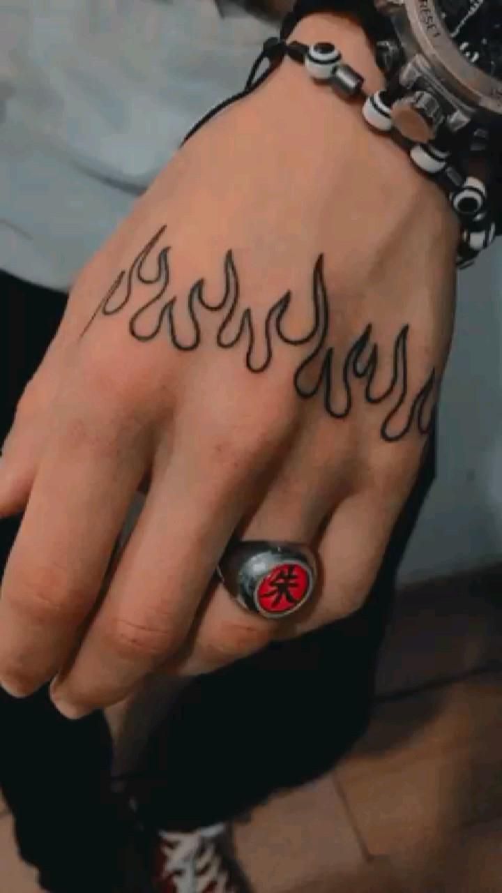 a person with a tattoo on their hand holding onto a wrist and wearing a watch