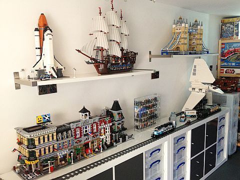 a room filled with lots of toys and legos on top of white shelves next to each other