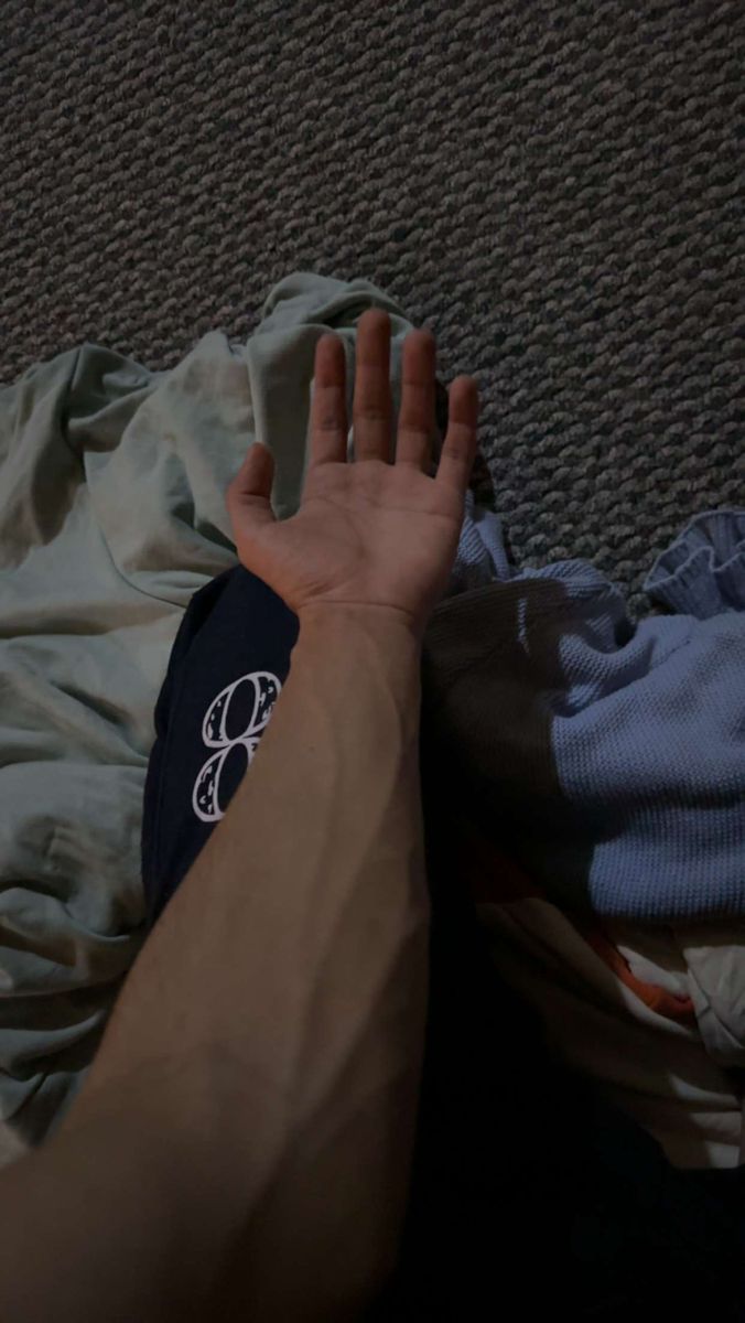 a person is laying on the floor with their hand up to his chest and there is a cloth covering them