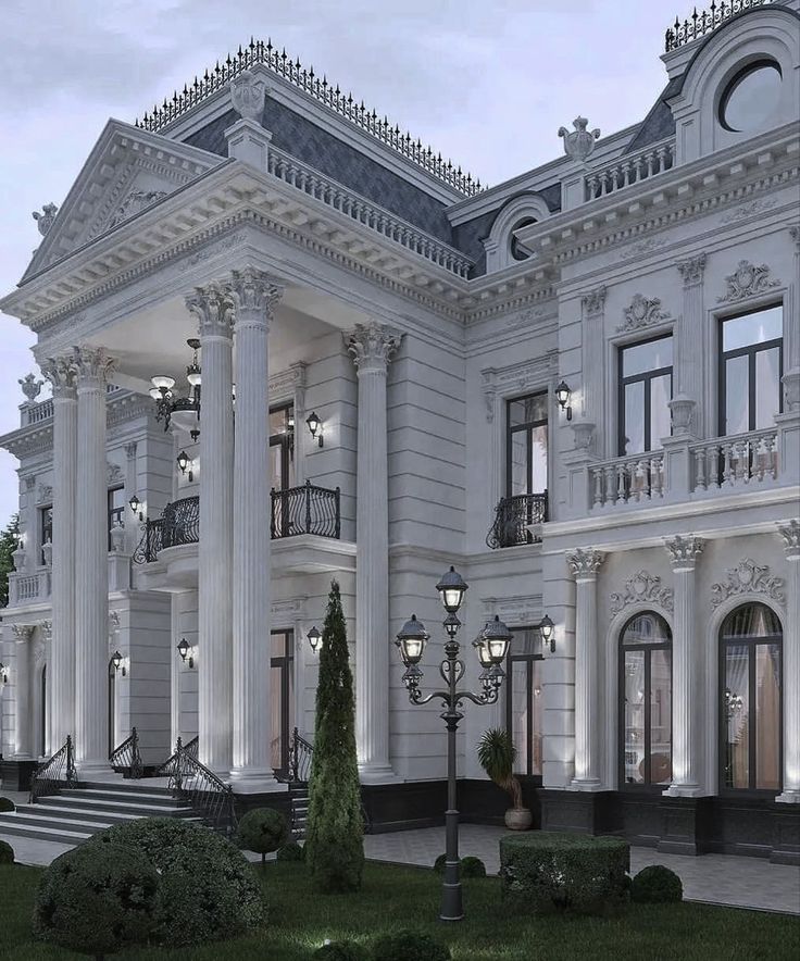 a large white building with columns and lights on it's front entrance at night