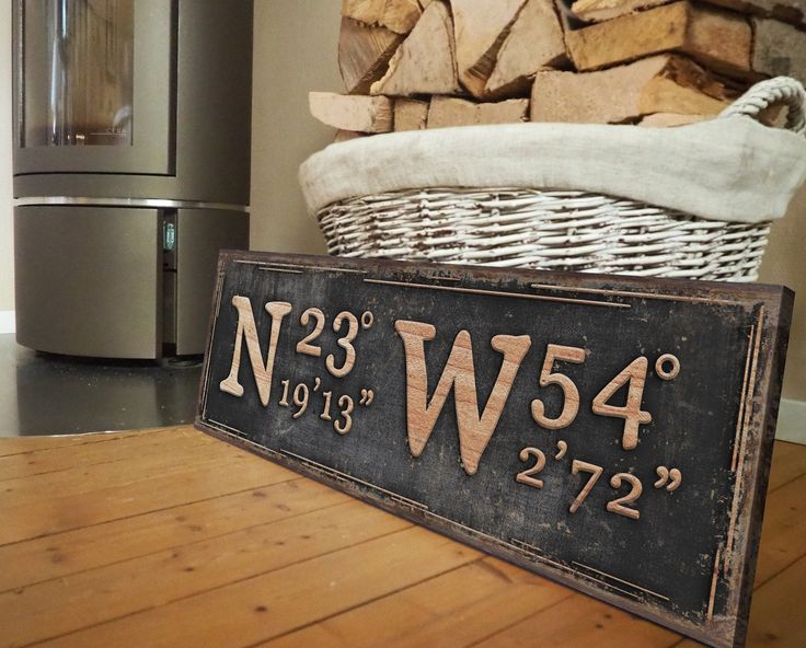 a sign sitting on top of a wooden floor next to a pile of firewood